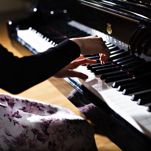 Close-up photo of a pianist's hands on the keys.